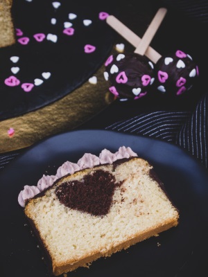 Ein Stück veganer Herzkuchen mit Vanille und Schokolade und Cake-Pops